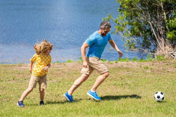 Childhood memories of son and his dad. dad have fun with his son. dad and son enjoying childhood adventures outdoor. dad and son playing football during their childhood. great fatherhood. - Фото, изображение