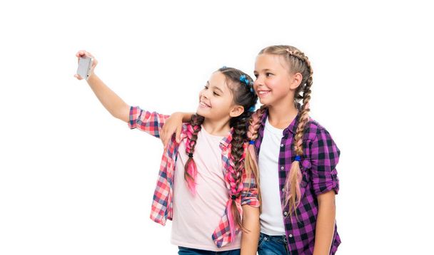 girls children having selfie time. school friends capture fun with selfie. friendship concept. heartwarming friendship selfie. school children making selfie. With smiles and laughter. - Valokuva, kuva