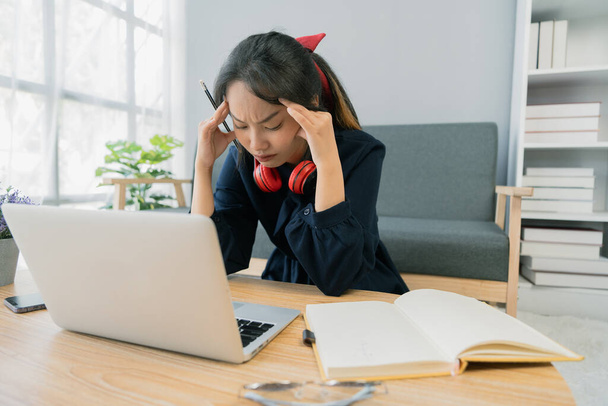 Asian student young woman stress while study on laptop, Asian young woman had headache while study. - Valokuva, kuva