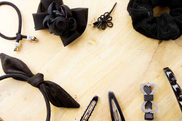 Black hair accessories on table wood background with space. - Photo, Image
