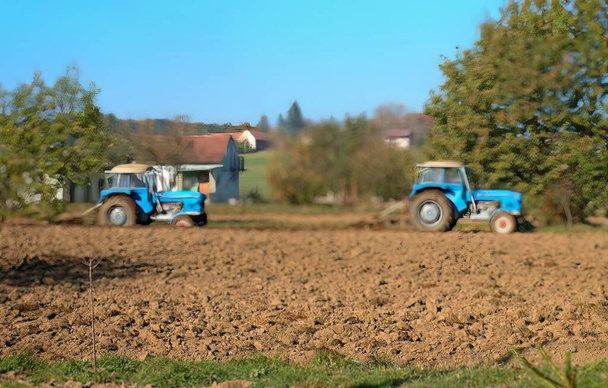 Zwei blaue Traktoren auf einem Feld. - Foto, Bild