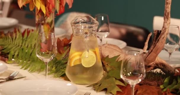 Un decantador con limonada sobre la mesa, que se sirve en estilo otoñal sobre el tema del otoño. - Imágenes, Vídeo