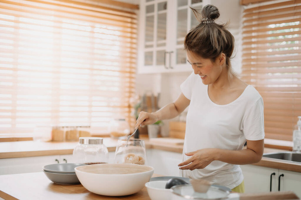 Asian woman enjoy cooking simple noodle in the kitchen as a hobby. - Valokuva, kuva