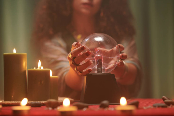 Closeup image of fortune teller touching crystal ball trying to see future - Φωτογραφία, εικόνα
