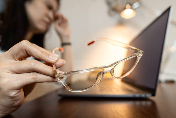 Väsynyt nainen, jolla on huonoja silmälaseja, näöntarkkuustestin ongelma tai virheellinen silmän mittausvirhe, nainen käyttää epätyypillisiä silmälaseja kärsii silmärasituksesta, näön hämärtymisestä, reseptilasien käsitteestä - Valokuva, kuva