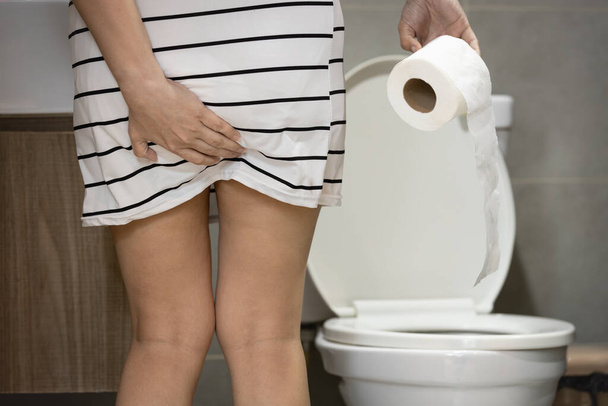 Asian woman suffering from Anal fissure,Haemorrhoids,hold her bottom,painful and swollen in the region of anus,hemorrhoid were acting up,anal pain,symptoms of constipation,hard feces,health problems - 写真・画像
