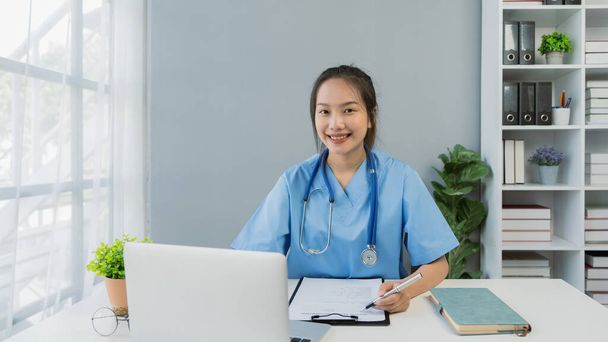 Professional Young Woman Asian doctor using laptop working on desk in the clinic. - Foto, afbeelding