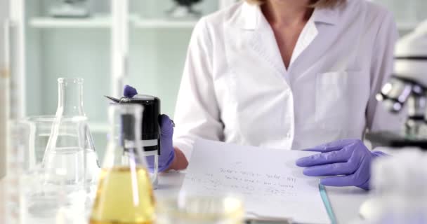 Lavoratore di laboratorio in guanti di gomma stampa francobolli sul riassunto medico per l'analisi e mette firma. Donna scienziata conferma le informazioni sulla ricerca nel documento - Filmati, video