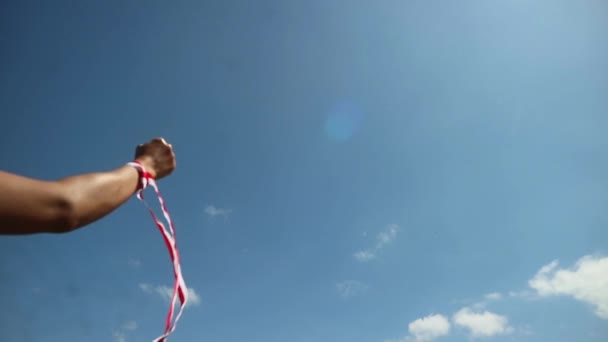 Kézzel viselt piros-fehér szalag, égi háttérrel, Indonézia függetlenségi nap koncepció - Felvétel, videó