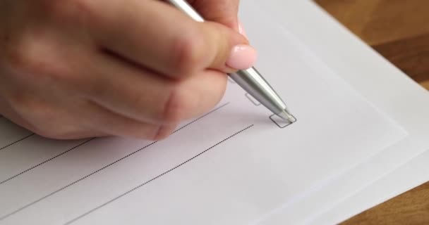 Frau hakt leere Kästchen beim Ausfüllen des Bewerbungsformulars im Büro ab. Kunde sitzt mit Stift auf Papier in Zeitlupe an hölzernen Tischfüllstellen - Filmmaterial, Video