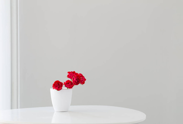 red roses in white vase in white interior - Foto, afbeelding