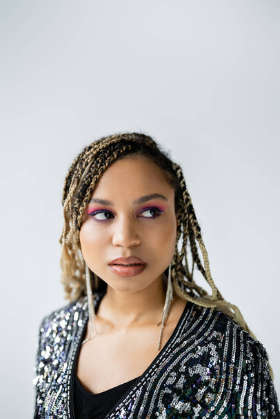portrait of dreamy african american woman looking away on grey background, bold makeup, attractive - Photo, Image
