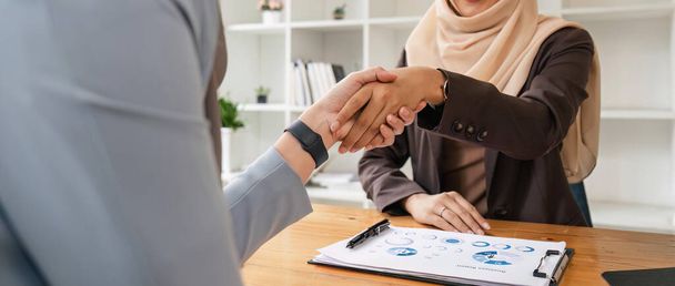 Két hidzsáb ázsiai nő kezet rázott egy startup céges találkozó után. egy fiatal, tehetséges nő vezeti. A menedzsment koncepció működteti a vállalatot, hogy növelje a céget. - Fotó, kép