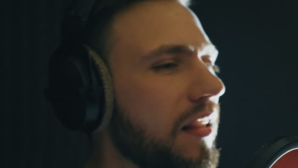 Portrait of young singer singing in sound studio. Handsome man emotionally recording new song. Guy sings to microphone. Working of creative musician. Show business concept. Slow motion Close up. - Footage, Video