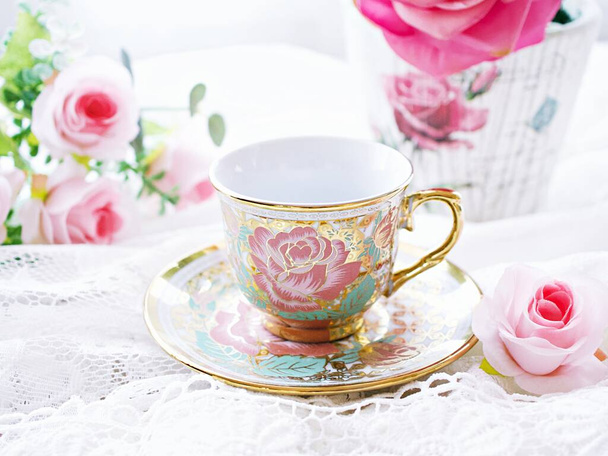 Антикварна чашка чаю з рожевою трояндою на білому тлі , Англійський чай вінтажний тон День матері , гарний фон , Китайська традиційна , кавова чашка , порцелянова чашка  - Фото, зображення