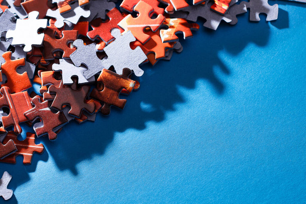 Mixed Peaces of a Colorful Jigsaw Puzzle Lie on the Blue Background With Copy Space - Strategy and Solving Problem Concept - Photo, Image