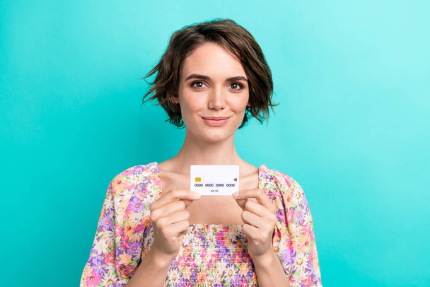 Portrait of gorgeous friendly positive lady hands hold showing plastic debit card isolated on turquoise color background. - 写真・画像