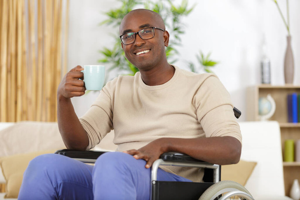 mature man in wheelchair drinking coffee - Foto, imagen
