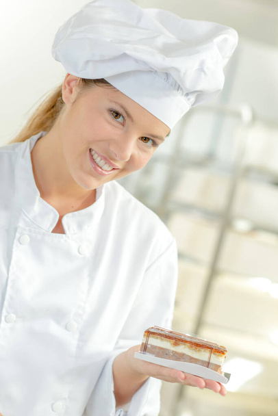 chef holding individual cake in palm of her hand - Φωτογραφία, εικόνα