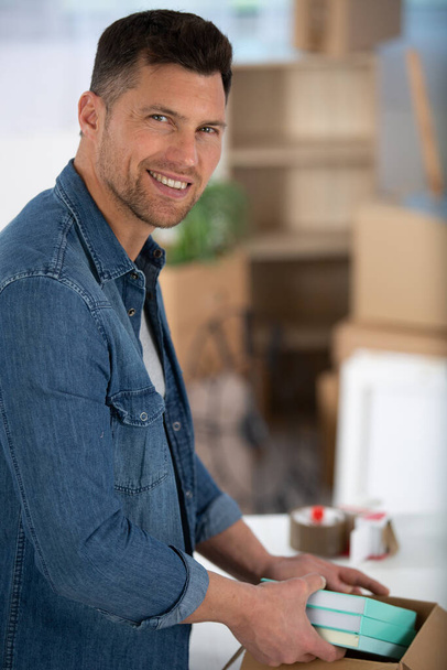 smiling man with cardboard box - Фото, зображення