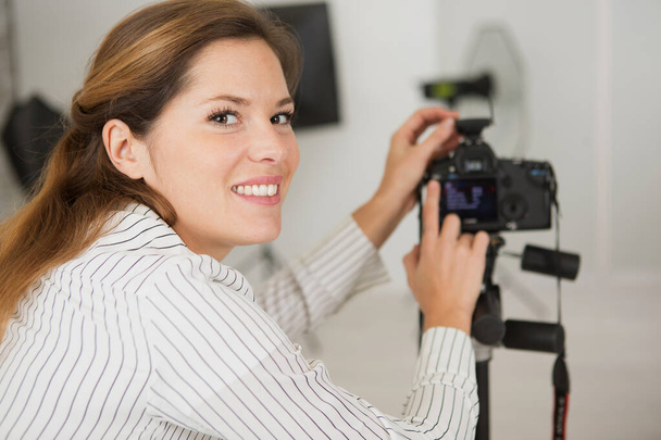 portrait of young attractive woman photographer in studio - Photo, Image