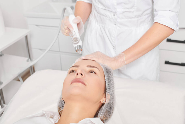 Kosmetolog sprawia, że gaz twarzy płynny tlen serum peeling naskórka do odmładzania kobieta pielęgnacja twarzy, zabieg kosmetyczny anti aging w salonie spa uroda. Kosmetyk sprawia, że leczenie skóry twarzy - Zdjęcie, obraz