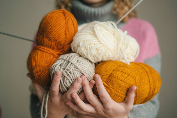 Womans hands holding multi-colored balls of wool yarn. Minimalistic creative medicine concept - Photo, Image