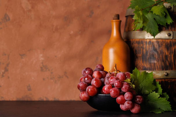 Винна пляшка і пишний виноград, що демонструє мистецтво виноробства. За допомогою простору копіювання
 - Фото, зображення