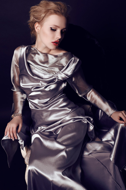 woman with blond hair and bright makeup wearing  luxurious silver dress  - Foto, Imagem