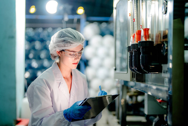 wetenschapper controleren van de kwaliteit van omgekeerde osmose machine systeem in de industriële fabriek. Gegevens van vrouwelijke werknemers in het controlepaneel met meetdruk voor de recyclage van draagbare installaties. - Foto, afbeelding