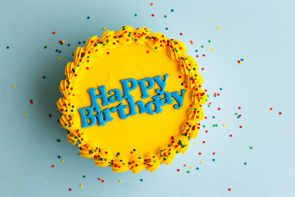 Mavi doğum günü pastası, mavi doğum günü tebriği ve mavi arka planda şeker serpiştirilmiş. - Fotoğraf, Görsel