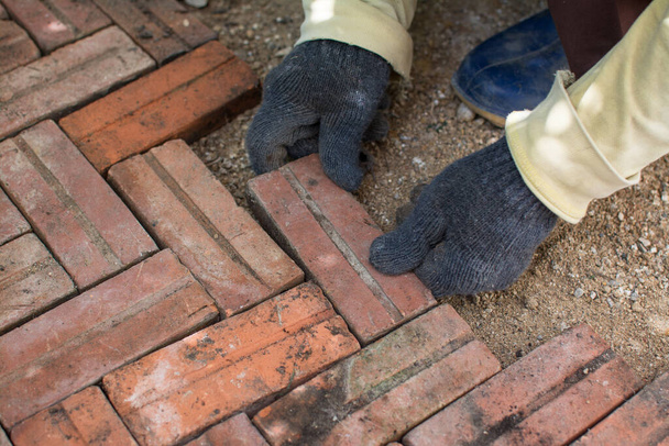 worker laying red brick  pathway around the house - Foto, Imagem