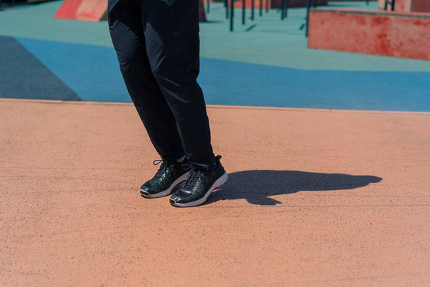 крупным планом ног в спортивной одежде и кроссовках на спортивной площадке - Фото, изображение