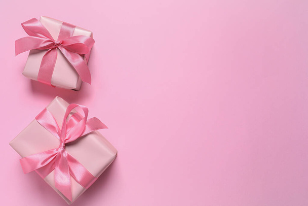 Beautiful gift boxes on pink background, flat lay. Space for text - 写真・画像