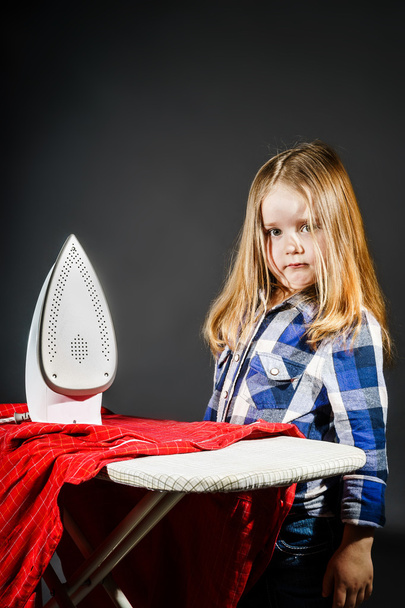 Cute little girl helping your mother by ironing clothes, contras - Foto, afbeelding