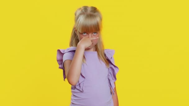 I am watching you. Young cute blonde school girl pointing at her eyes and camera, show I am watching you gesture, spying on someone. Preteen female child kid isolated on studio yellow background - Footage, Video