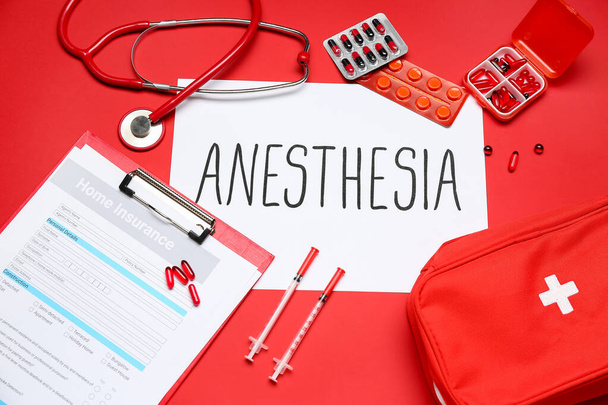Papel con palabra ANESTESIA e insumos médicos sobre fondo rojo - Foto, Imagen