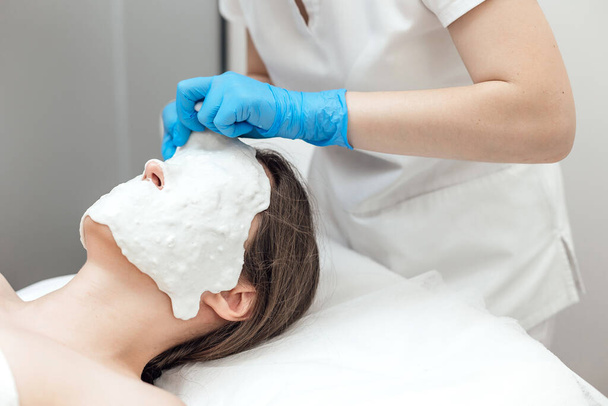 Facial Skin Treatment. Woman Receiving Cosmetic Mask In Beauty Salon - Foto, Imagem