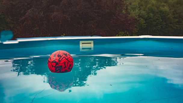 ball floating in a blue garden pool at a time when everything is quiet - Fotoğraf, Görsel