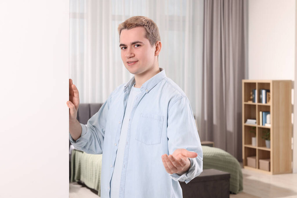 Happy man inviting to come in room - Photo, image