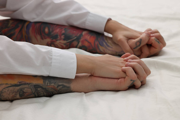 Passionate couple having sex on bed, closeup of hands - Fotó, kép