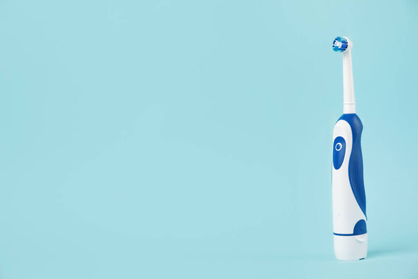 Electric toothbrush on light blue background, space for text - Foto, Imagem