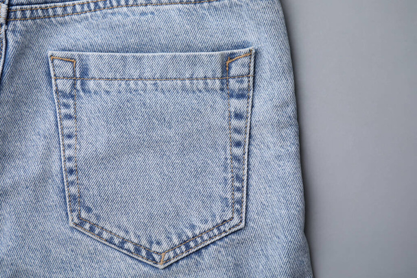 Jeans with pocket on grey background, top view - Fotografie, Obrázek