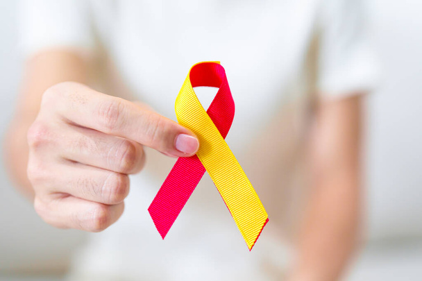 жінка тримає червону та жовту стрічки. Місяць обізнаності про гепатит, 28 липня, рак печінки, джуніци, цироз, невдача, збільшення, гепатична енцефалопатія та концепція здоров'я - Фото, зображення