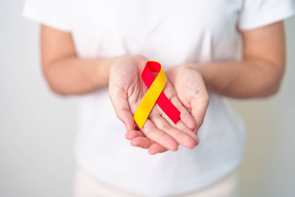 woman holding Red and Yellow ribbon. World hepatitis day awareness month, 28 July, Liver cancer, Jaundice, Cirrhosis, Failure, Enlarged, Hepatic Encephalopathy and Health concept - Foto, Bild