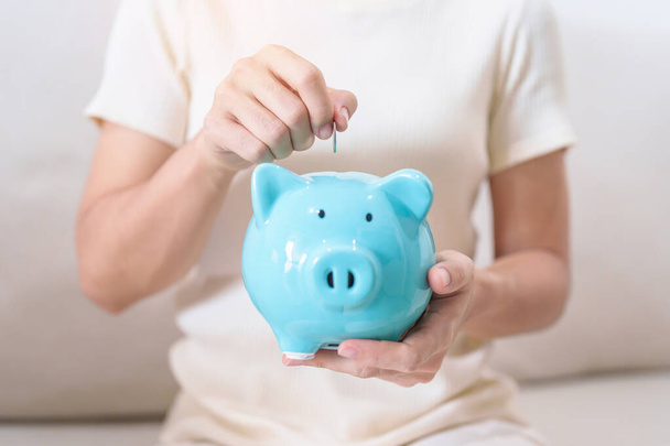 Money Saving for Future Plan, Retirement fund, Pension, Investment, Wealth Business and Financial concepts. hand holding and putting into piggy bank, Money Counting for World Savings day and Donate - Photo, Image