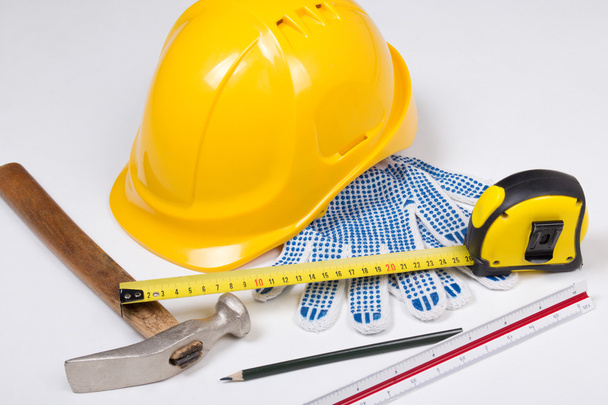 herramientas de trabajo del constructor y el casco amarillo sobre blanco - Foto, imagen