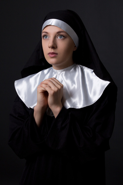 concepto de religión - joven monja rezando sobre gris - Foto, imagen
