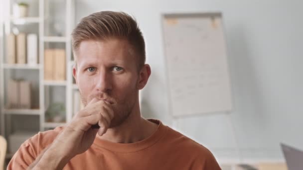 Medium close-up portret van jonge blanke man roken elektronische sigaret en glimlachen op camera op kantoor - Video