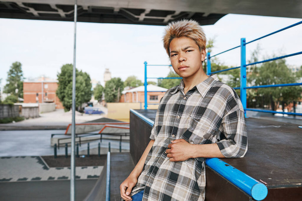 Περιμένετε μέχρι πορτρέτο του έφηβος αγόρι κοιτάζοντας κάμερα στο skatepark σε εξωτερικούς χώρους στην αστική περιοχή, αντίγραφο χώρου - Φωτογραφία, εικόνα